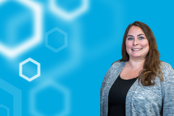 Registrar Laura Cross (right) over a blue background with white hexagons on the left.